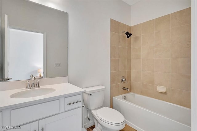 full bathroom featuring vanity, tiled shower / bath combo, and toilet