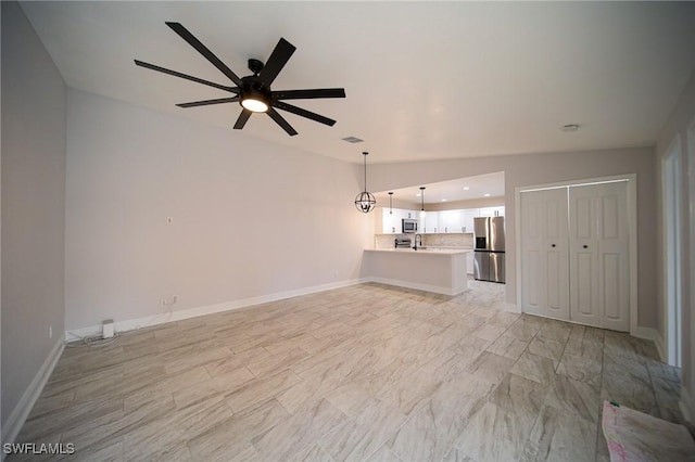 unfurnished living room featuring ceiling fan and vaulted ceiling