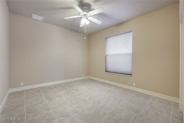 tiled spare room featuring ceiling fan