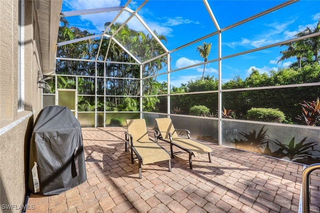 view of patio / terrace with glass enclosure and a grill