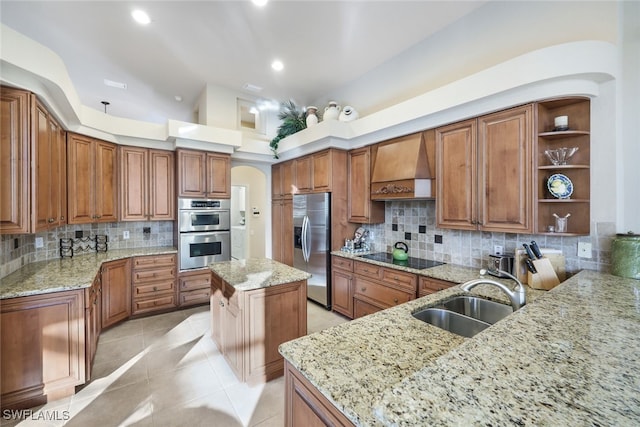 kitchen featuring custom exhaust hood, a kitchen island, light stone counters, and appliances with stainless steel finishes