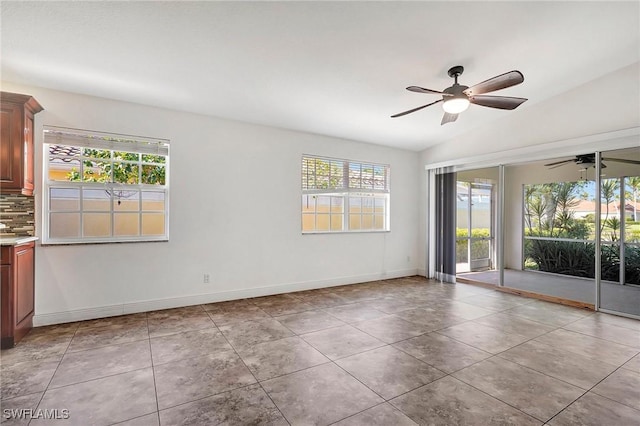 tiled empty room with ceiling fan and lofted ceiling