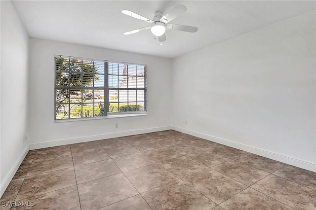 empty room with ceiling fan and light tile patterned flooring