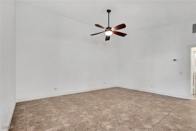 tiled spare room featuring ceiling fan