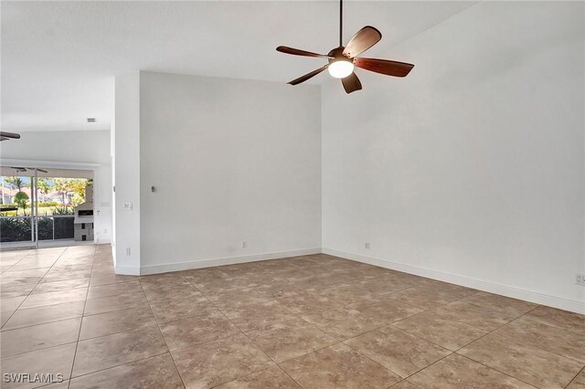 empty room with ceiling fan, lofted ceiling, and light tile patterned floors