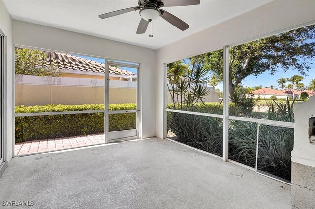 unfurnished sunroom featuring ceiling fan