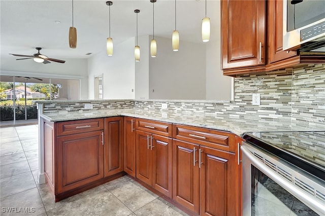 kitchen featuring tasteful backsplash, light stone counters, ceiling fan, hanging light fixtures, and stainless steel range with electric cooktop