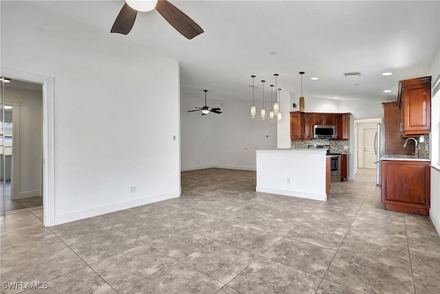 kitchen featuring decorative backsplash, appliances with stainless steel finishes, a kitchen island, and hanging light fixtures