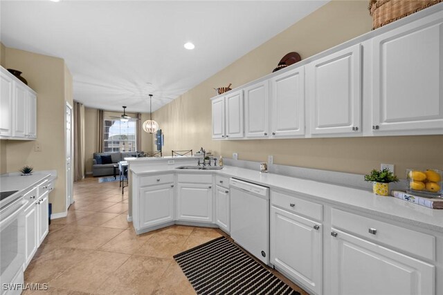 kitchen featuring kitchen peninsula, dishwasher, white cabinets, and pendant lighting