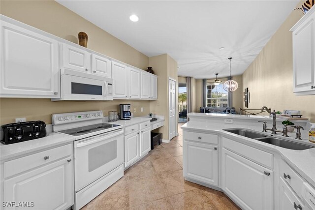 kitchen with pendant lighting, white appliances, sink, white cabinetry, and a chandelier