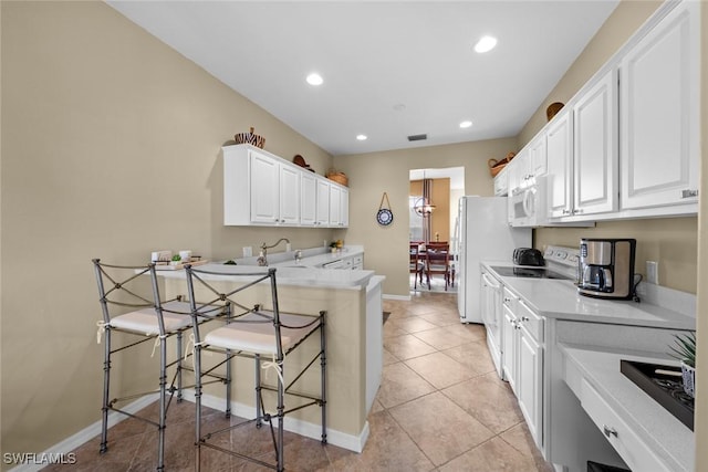 kitchen with a kitchen bar, kitchen peninsula, white cabinetry, stainless steel range with electric cooktop, and light tile patterned flooring