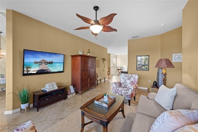 living room featuring ceiling fan, light tile patterned floors, and lofted ceiling