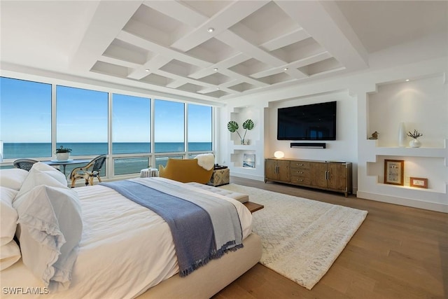 bedroom with floor to ceiling windows, coffered ceiling, wood-type flooring, a water view, and beamed ceiling