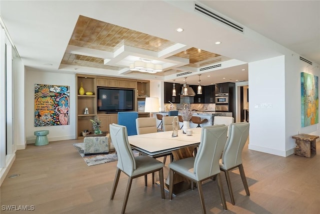 dining space with light wood-type flooring, a tray ceiling, and built in shelves