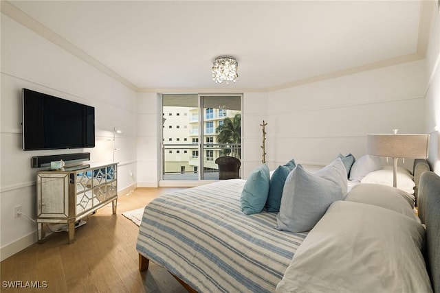 bedroom featuring access to exterior, crown molding, and hardwood / wood-style flooring