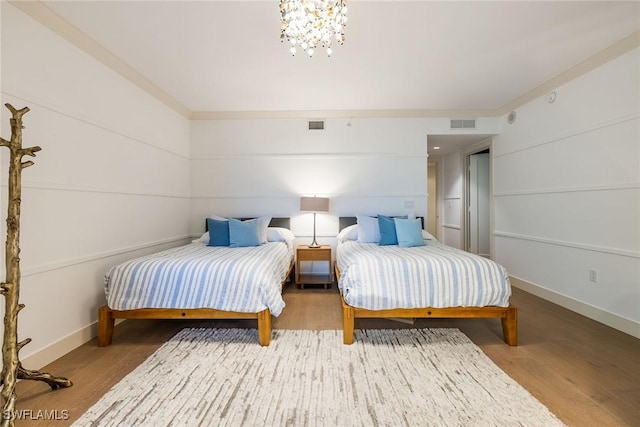 bedroom with wood-type flooring and a notable chandelier