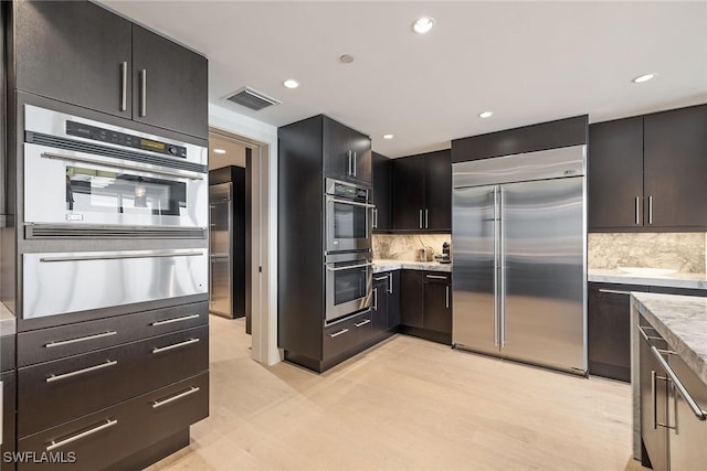 kitchen with decorative backsplash, light hardwood / wood-style flooring, and stainless steel appliances