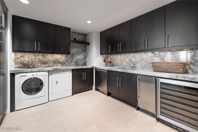 kitchen featuring sink, wine cooler, backsplash, and washing machine and clothes dryer