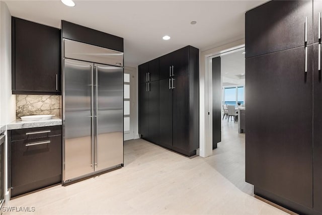 kitchen with stainless steel built in fridge and tasteful backsplash