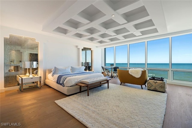 bedroom featuring hardwood / wood-style floors, beamed ceiling, a water view, and coffered ceiling