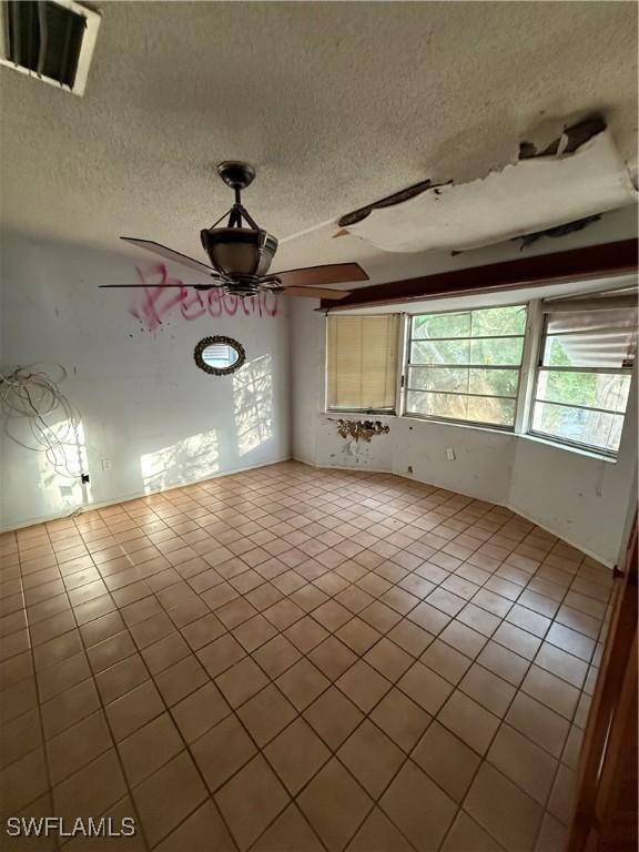 tiled spare room with a textured ceiling