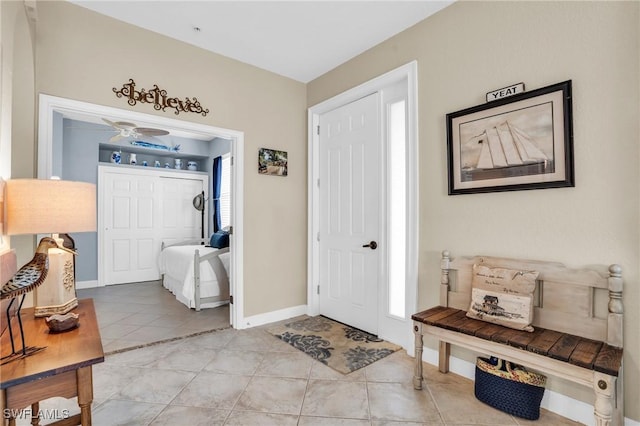 tiled foyer featuring ceiling fan