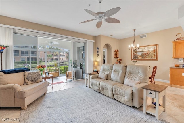 living room with ceiling fan with notable chandelier and light tile patterned floors