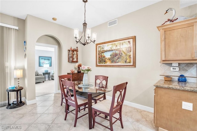 tiled dining area with an inviting chandelier