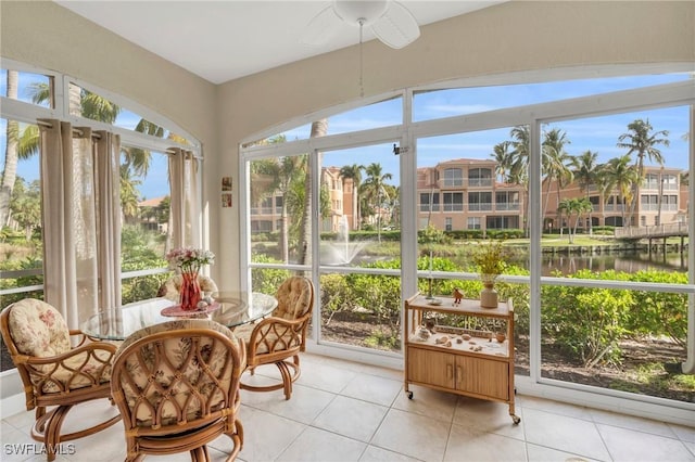 sunroom with a water view and ceiling fan