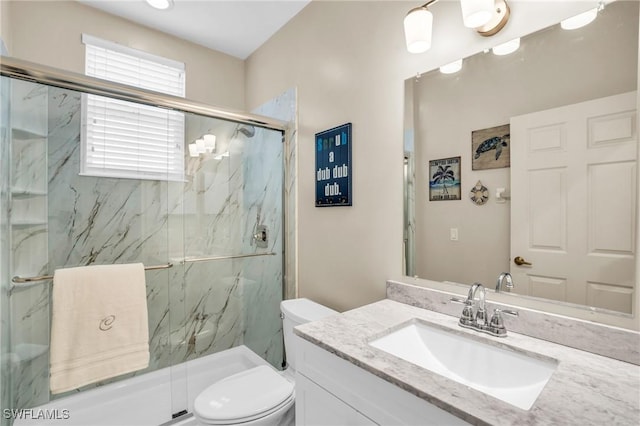 bathroom featuring vanity, toilet, and a shower with door