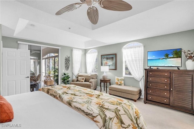 bedroom with a raised ceiling, access to exterior, ceiling fan, and light carpet