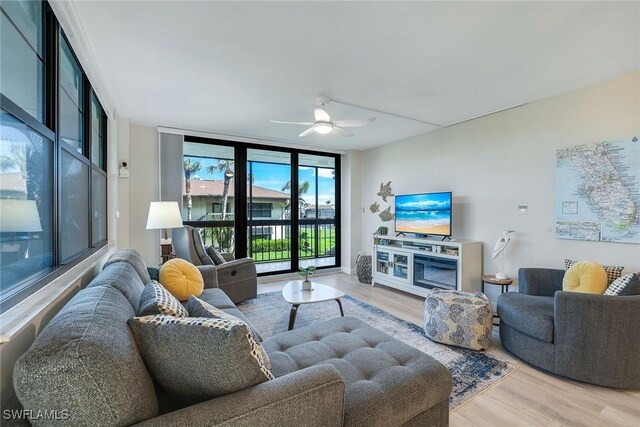 living room with hardwood / wood-style flooring, ceiling fan, and floor to ceiling windows