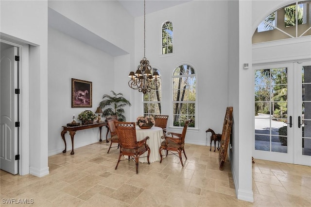 sitting room with a chandelier, french doors, and a towering ceiling