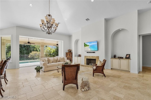 living room with ceiling fan with notable chandelier and high vaulted ceiling