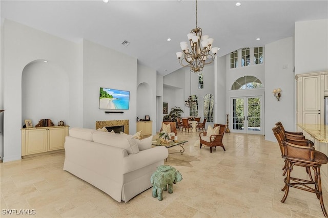 living room with french doors, a high ceiling, and an inviting chandelier