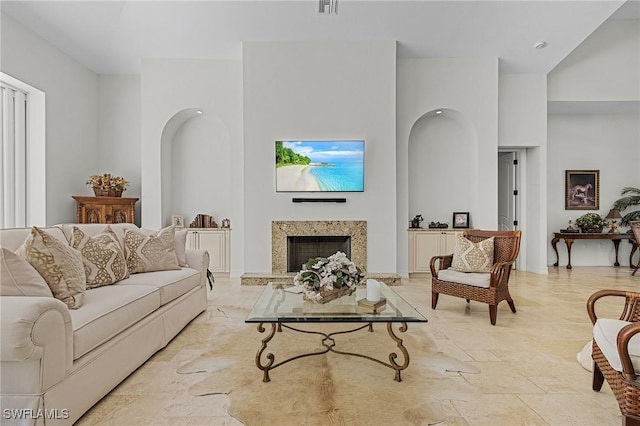 living room featuring a fireplace and a towering ceiling