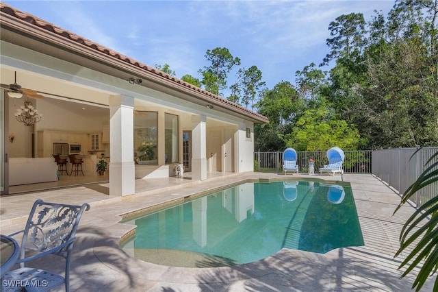 view of swimming pool with ceiling fan and a patio