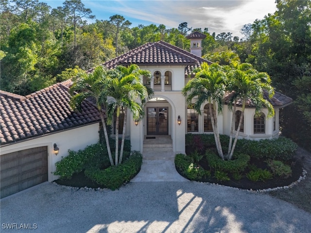 mediterranean / spanish-style home with french doors and a garage