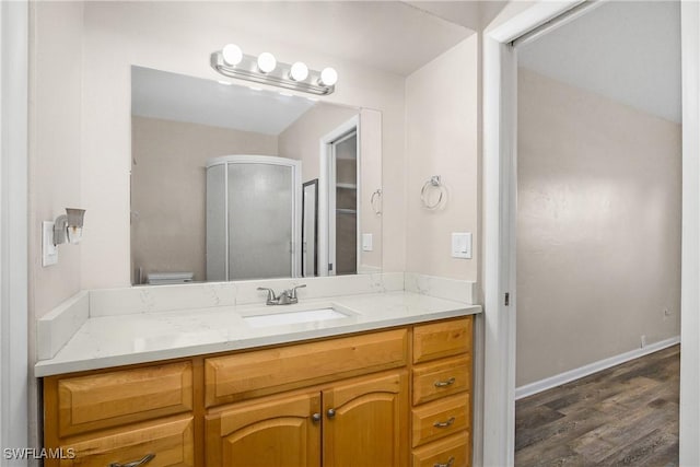 bathroom with hardwood / wood-style floors, vanity, a shower with door, and toilet