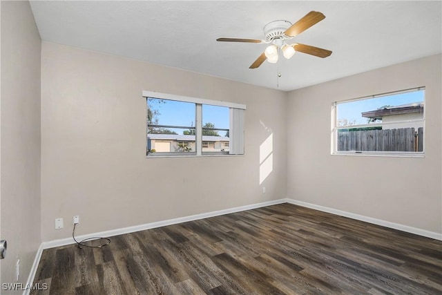 empty room featuring dark hardwood / wood-style floors, a wealth of natural light, and ceiling fan