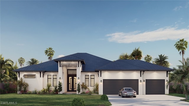 view of front of home with a front yard, driveway, stucco siding, a garage, and metal roof