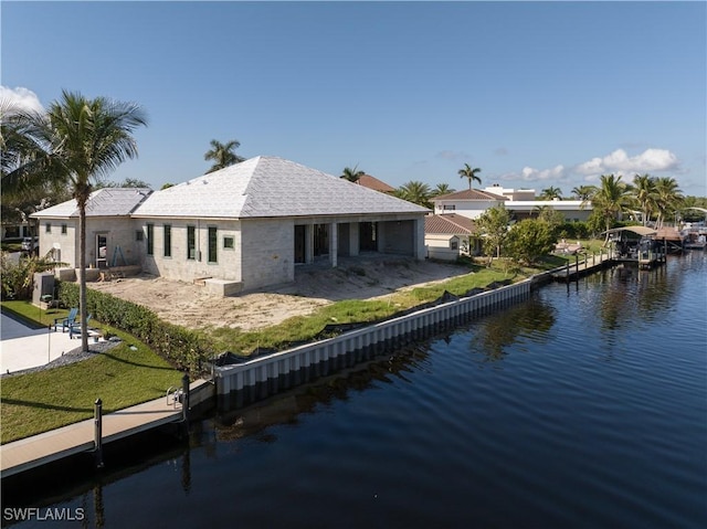 back of house featuring a water view and a yard