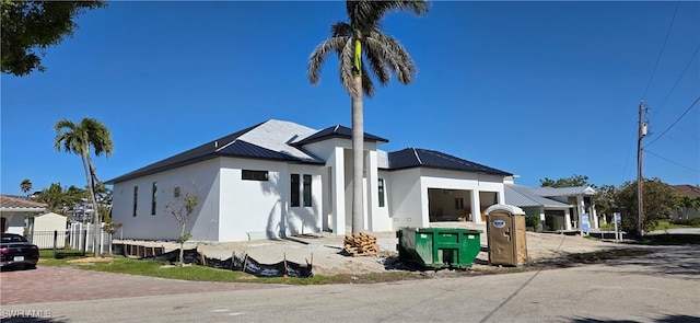 view of front of home with a standing seam roof, metal roof, a garage, and stucco siding