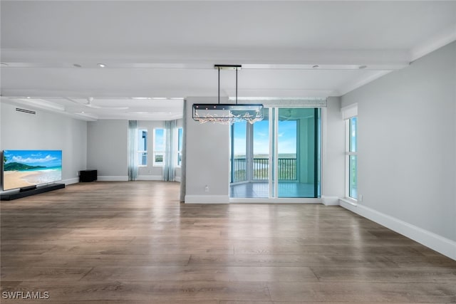 unfurnished living room with hardwood / wood-style flooring, beamed ceiling, and a chandelier