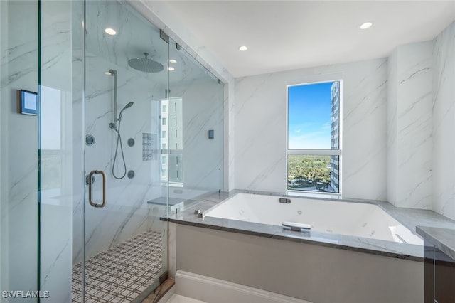 bathroom with tile walls and shower with separate bathtub