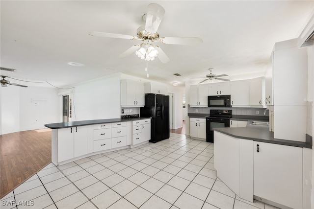 kitchen featuring kitchen peninsula, sink, black appliances, light tile patterned floors, and white cabinets