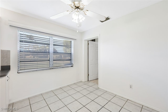 tiled empty room featuring ceiling fan