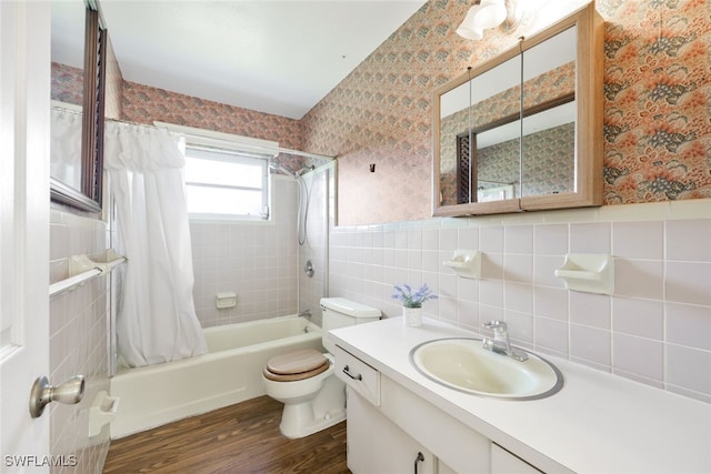 full bathroom with vanity, wood-type flooring, shower / bathtub combination with curtain, tile walls, and toilet