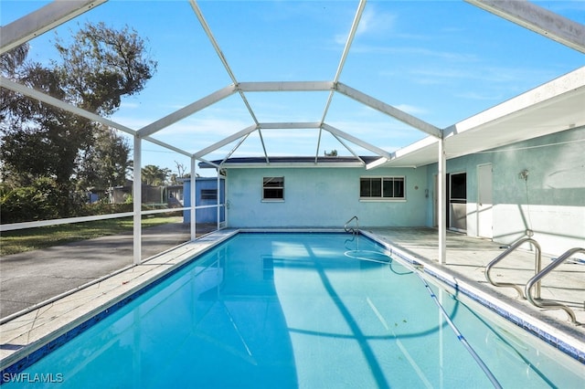 view of pool featuring glass enclosure and a patio area