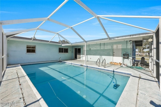 view of swimming pool featuring a lanai and a patio